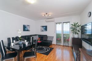a living room with a table and a couch at Apartments Beverly in Omiš