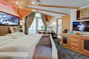 a hotel room with a large bed and a tv at Alpinstyle Hotel Ischgl in Ischgl