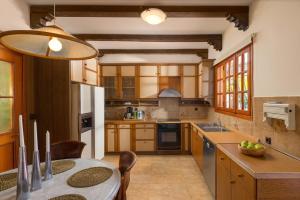 a kitchen with wooden cabinets and a table in it at Una Villa Rhodes in Ixia