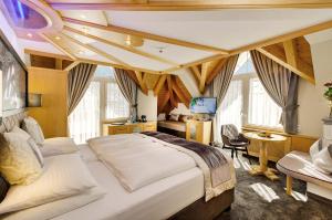 a bedroom with a large white bed in a room with windows at Alpinstyle Hotel Ischgl in Ischgl
