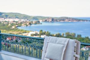 a chair sitting on a balcony overlooking the water at Villa Bamour With Paradise View in Ancient Epidauros