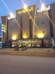 ein großes Gebäude mit Lichtern davor in der Unterkunft Al Muhaidb Al Nadwa in Riad