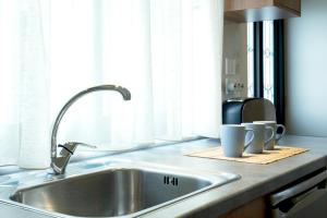a kitchen counter with a sink and two mugs at Gramvoussa Bay in Kissamos