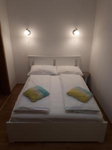 Una cama blanca con dos almohadas encima. en Apartment Viki, en Makarska