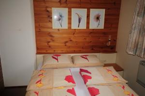 a bed in a bedroom with pictures on the wall at Appt. ÄISCHER in Wilwerwiltz