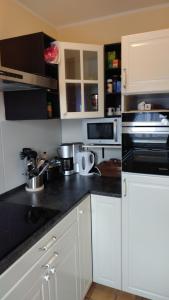 a kitchen with white cabinets and black counter tops at Haus Spitzenblick in Friedrichskoog