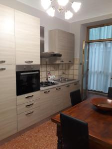 uma cozinha com uma mesa de madeira e uma cozinha com uma sala de jantar em IL PORTONE VERDE em Turim