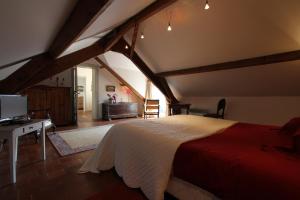 um quarto com uma cama grande num sótão em Le Clos Xavianne em Ribécourt-la-Tour