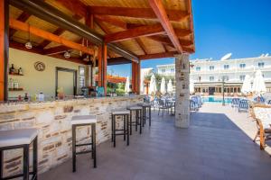 a patio with a bar with chairs and a pool at Georgia Plus - All Inclusive in Afantou