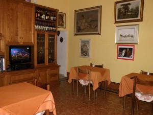 a restaurant with two tables and a tv in a room at Hotel kim in Viareggio