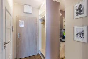 korytarz z drzwiami prowadzącymi do kuchni w obiekcie Okrzei 18 - studio by Homeprime w Warszawie