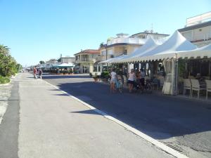 un grupo de personas caminando por una calle con una tienda de campaña en Hotel kim en Viareggio