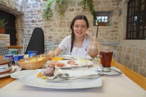a woman sitting at a table with a plate of food at Villa Nora Hvar in Hvar