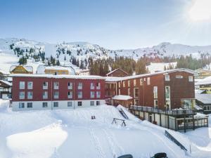 a snow covered slope in front of a building at JUFA Hotel Planneralm in Planneralm
