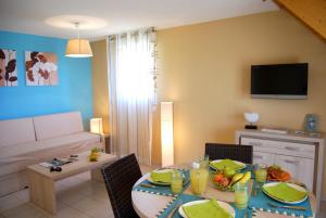 a living room with a table and a couch at Résidence Lagrange Vacances Le Mas de Torreilles in Torreilles