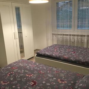 1 dormitorio con 2 camas y colcha con flores en Sulzberg, en Lahr