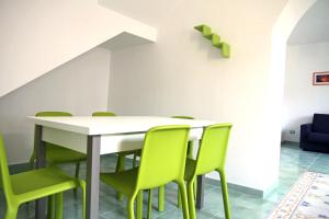 a dining room with a table and green chairs at Appartamento ALICANTE in Canneto