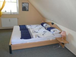 a bedroom with a bed with blue and white sheets at Ferienwohnung Ankerplatz_VOLB in Ostseebad Karlshagen