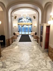 a lobby with a large marble floor and a chandelier at Grand Hotel Bellevue - Grand Place in Lille