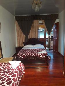 Bonsai Hotel Salamina Caldas في Salamina: غرفة نوم مع سرير زرافة في غرفة
