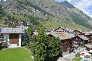 una pequeña ciudad en las montañas con una montaña en Hotel Rhodania en Zermatt