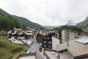 Vistas a una ciudad con una montaña en el fondo en Hotel Rhodania, en Zermatt