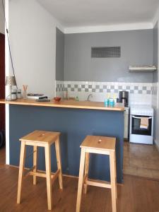 a kitchen with two wooden stools and a counter top at Home Opéra in Marseille