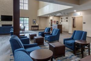 uma sala de espera com cadeiras e mesas azuis em Comfort Suites - South Austin em Austin