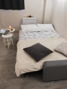 twee bedden in een kleine kamer met een tafel en een nachtkastje bij Gîte ''Le nid de Bouly'' in Martres-de-Veyre