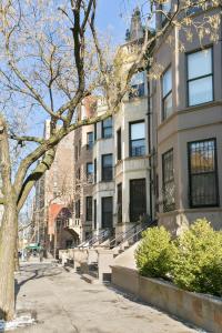 un bâtiment avec un arbre en face d'une rue dans l'établissement 2-bedroom in Upper West Side, private entrance, à New York