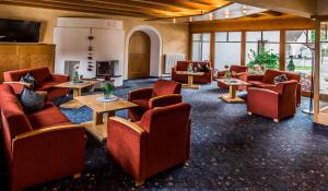 ein Wartezimmer mit Sofas, Tischen und Fenstern in der Unterkunft Hotel zum Goldenen Löwen in Biberwier