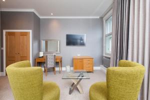 a living room with two chairs and a table at Aberdeen Douglas Hotel in Aberdeen