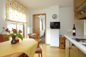 a kitchen with a table with a vase of flowers on it at Pension Epple in Oberjoch