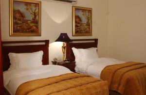 a hotel room with two beds and a lamp at Issham Hotel in Jeddah +55 photos