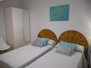 a bedroom with two beds and a painting on the wall at Apartamento pleno Centro junto Ayuntamiento in Logroño