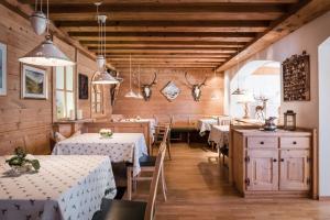 サン・ヴィジリオ・ディ・マレッベにあるDependance Hotel Mareo Dolomitesのテーブルと椅子、壁にアントラーが置かれたレストラン