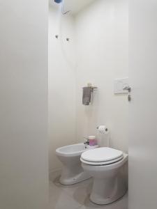 a white bathroom with a toilet in a room at Casa Antico Forno in Manciano