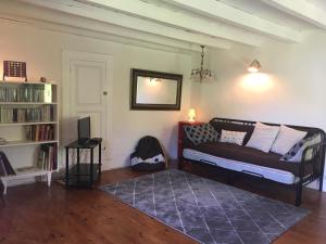 sala de estar con cama y estante para libros en Charmante maison familiale, en Saint-Pierre-de-Chartreuse