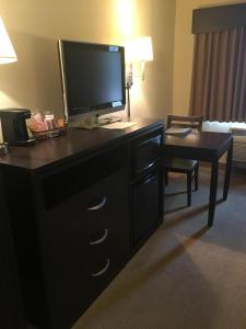 a hotel room with a dresser with a television on it at AmericInn by Wyndham Monmouth in Monmouth