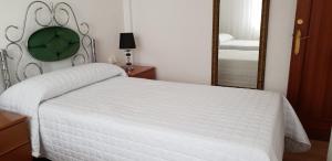 アーロにあるApartamento La Ruta Del Vinoのベッドルーム(白いベッド1台、鏡付)