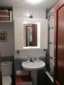 a bathroom with a sink and a toilet and a mirror at EA playa montaña45'GUGGEMHEIN in Ea