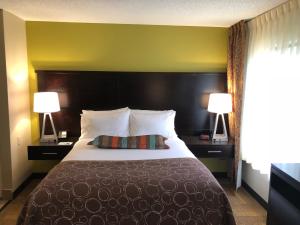 une chambre d'hôtel avec un grand lit et deux lampes dans l'établissement Staybridge Suites Grand Rapids-Kentwood, an IHG Hotel, à Grand Rapids