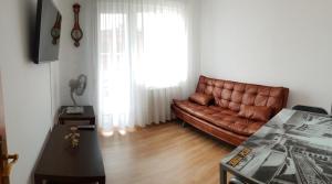 a living room with a brown leather couch in front of a window at Apartamento La Ruta Del Vino in Haro
