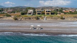 a beach with chairs and umbrellas on the sand at Great Sand Villa in Gennadi