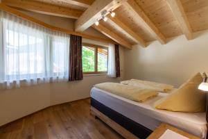 ein Schlafzimmer mit einem Bett und einem großen Fenster in der Unterkunft Pension&Appartements Marxenhof in Pertisau