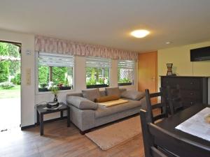 ein Wohnzimmer mit einem Sofa und einem Tisch in der Unterkunft Ferienbungalow Poppengrün in Poppengrün