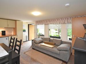 ein Wohnzimmer mit einem Sofa und einer Küche in der Unterkunft Ferienbungalow Poppengrün in Poppengrün