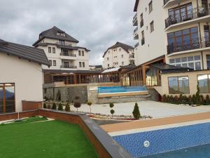 an apartment building with a lawn in front of it at Milmari Resort Premier 47 in Kopaonik