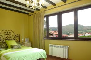 une chambre avec un lit et une grande fenêtre dans l'établissement La Riguera de Ginio, à Ucieda de Arriba