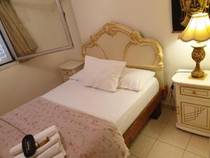 1 dormitorio con 1 cama con cabecero de oro y lámpara en Thai villa eilat - וילה תאי אילת, en Eilat